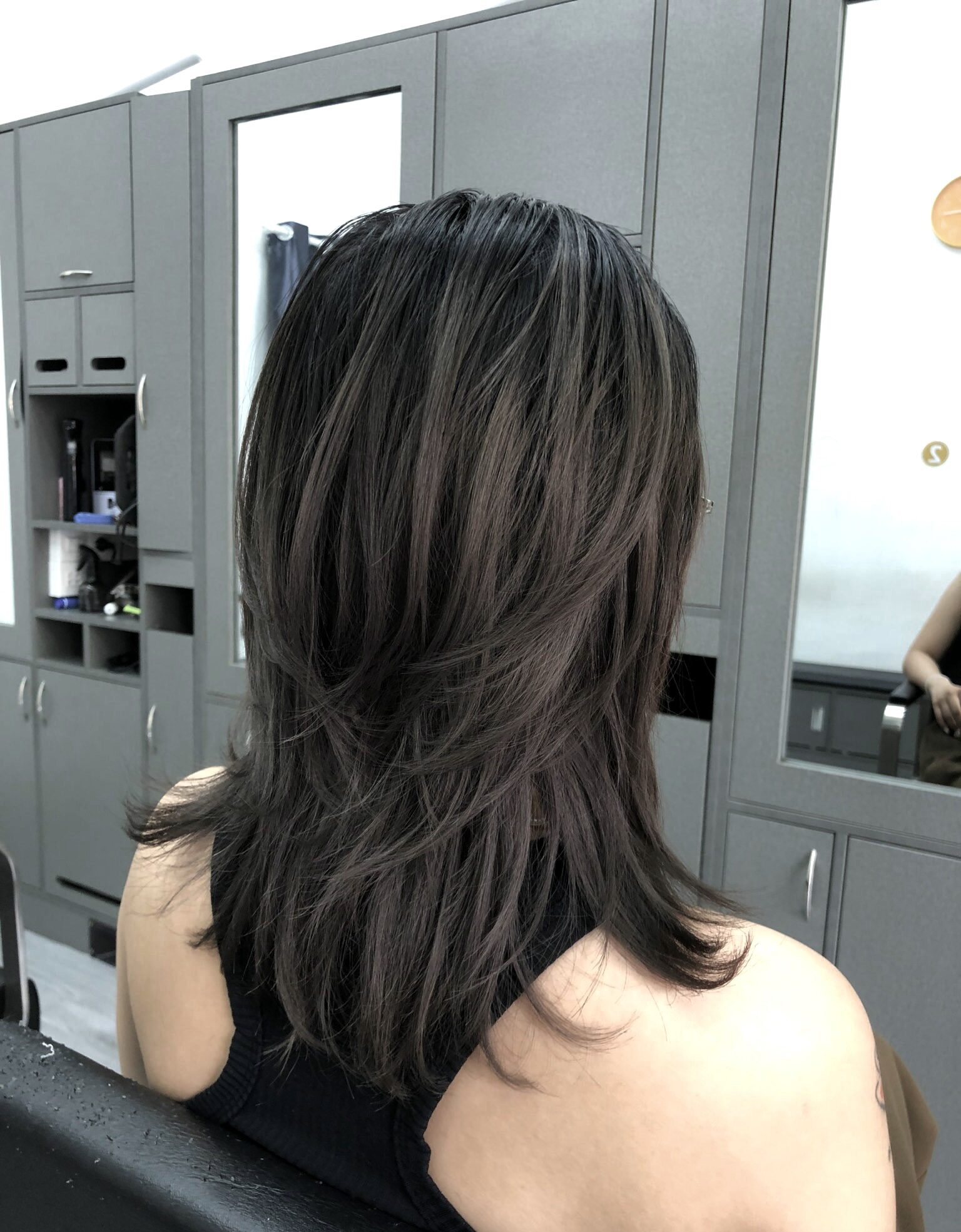Tóc dài qua vai tỉa nhiều lớp, phần đuôi xòe nhẹ, nhìn từ phía sau.