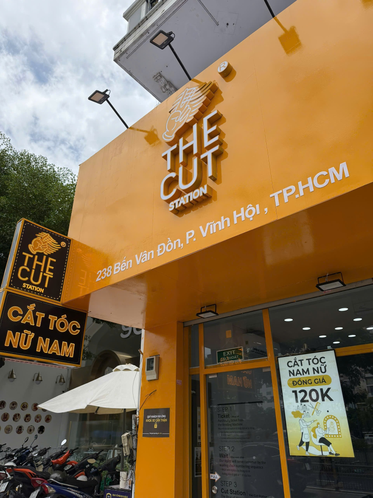 Biển hiệu The Cut Station và địa chỉ 238 Bến Vân Đồn nhìn từ bên cạnh.
