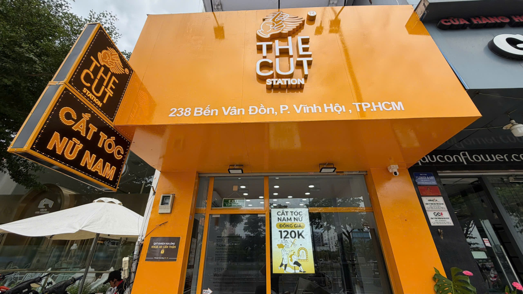 Mặt tiền The Cut Station 238 Bến Vân Đồn với biển địa chỉ và cửa kính.